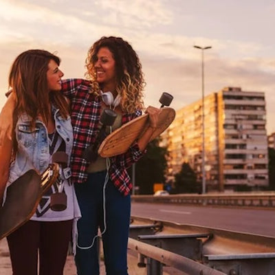 two women holding street skateboards